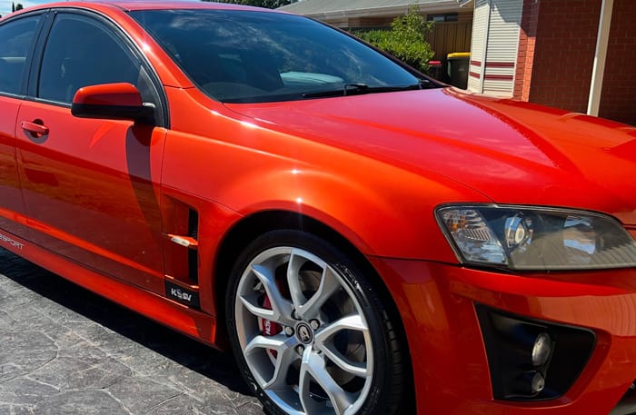 An orange HSV sedan with a deep gloss finish