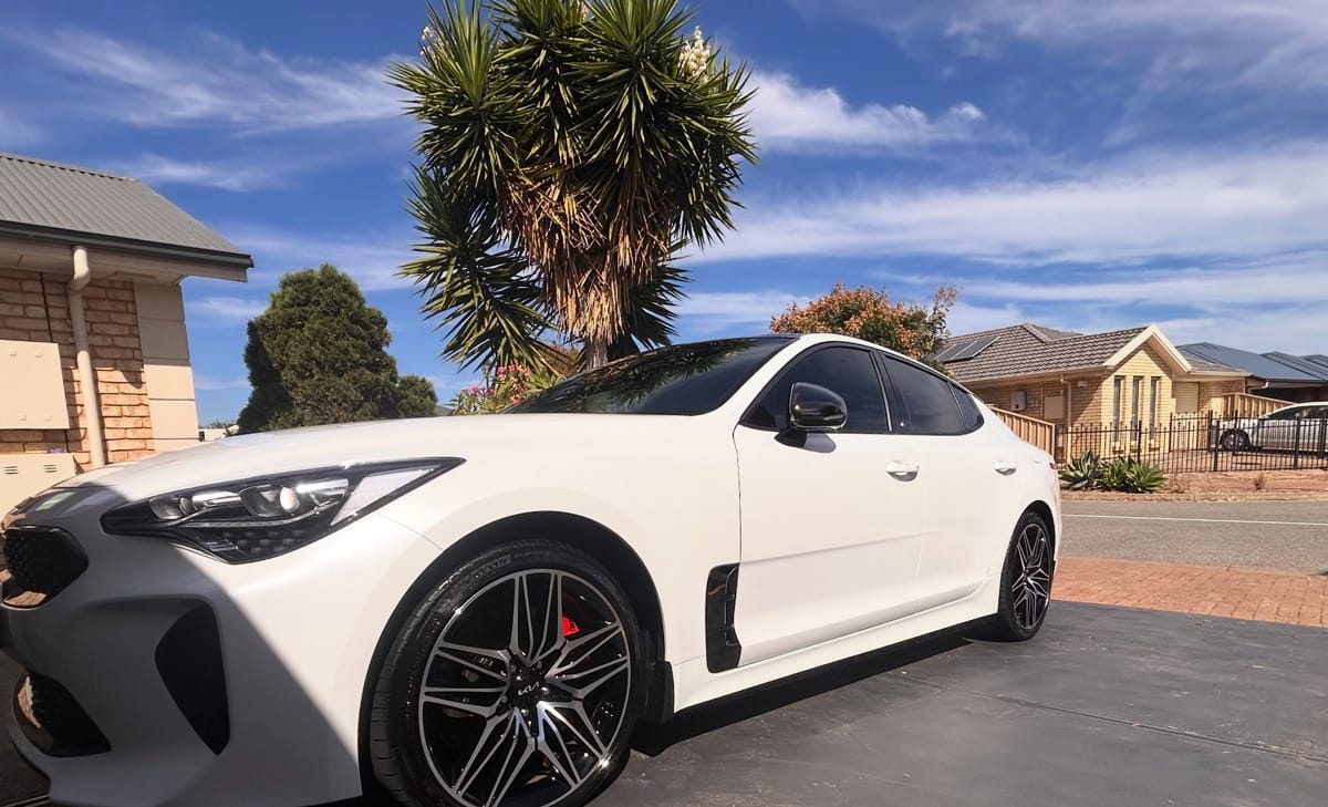 A white Kia Stinger freshly detailed in an Adelaide driveway